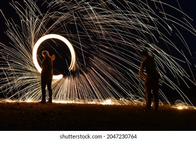 Iron wool circle drawing light fireworks. Burning Steel Wool spinning, Trajectories of burning sparks at night. Movement light effect, steel wool fire hoop. long exposure light painting, Pyrotechnic - Powered by Shutterstock