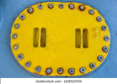 Iron, Yellow Ship Ballast Tank Cap On Gray Deck. Fuel Tank On Top.