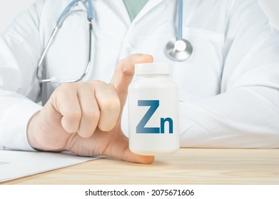 Iron Zinc Zn supplements for human health. Doctor recommends taking Zinc Zn iron. doctor talks about Benefits of Zinc. Essential vitamins and minerals for humans. Zn Health Concept. Blue background - Shutterstock ID 2075671606