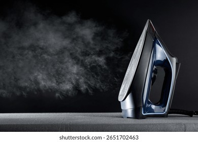 Ironing concept with steaming iron and stack of ironed and folded white shirts on black table and dark background. Front view.