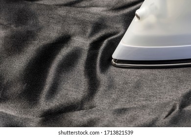 Ironing Of Delicate Smooth Soft Black Silk Fabric Close-up.