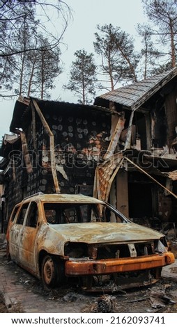 Irpin, Kyiv Oblast,  Ukraine: Cities of Ukraine after the Russian occupation. burned civilian car near destroyed civilian house in  city of Irpin, northwest of Kyiv
