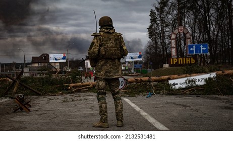 Irpin, Ukraine - 5 March 2022: Ukrainian soldier stands on the check point to the city Irpin near Kyiv during the evacuation of local people under the shelling of the Russian troops. 