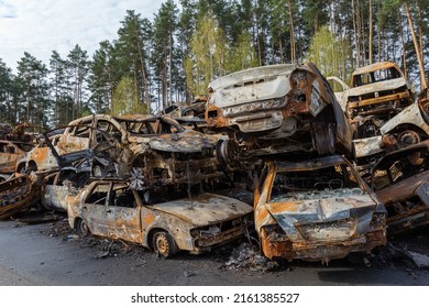 IRPIN, UKRAINE - April 27, 2022: Remains Of The Civil Cars Which Was Shot Up And Burned Out By Russian Soldiers During Evacuation Of Unarmed Peoples From War Zone In Russian Invasion, Car Graveyard 
