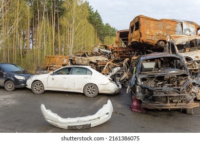 IRPIN, UKRAINE - April 27, 2022: Remains Of The Civil Cars Which Was Shot Up And Burned Out By Russian Soldiers During Evacuation Of Unarmed Peoples From War Zone In Russian Invasion, Car Graveyard 
