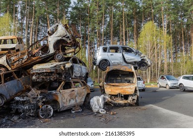 IRPIN, UKRAINE - April 27,2022: Remains Of The Civil Cars Which Was Shot Up And Burned Out By Russian Soldiers During Evacuation Of Unarmed Peoples From War Zone In Russian Invasion, Car Graveyard 
