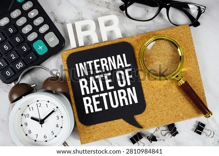IRR - Internal Rate of Return acronym with calculator, alarm clock and magnifying glass, business concept background