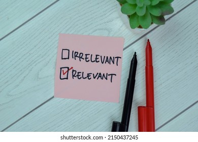 Irrelevant Versus Concept of Relevant write on sticky notes isolated on Wooden Table.