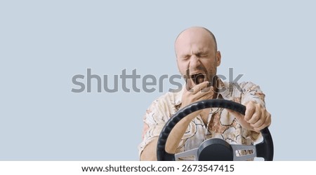 Irresponsible driver falling asleep while driving, he is holding the steering wheel and yawning, copy space