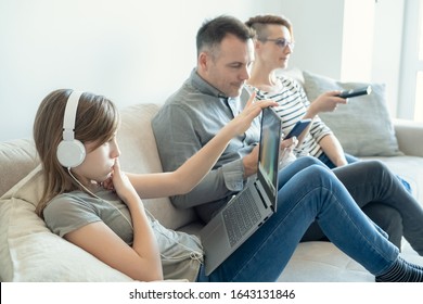 Irresponsible parents ignoring lonely daughter. Bored young girl using laptop on bed while mom and dad watching TV and not paying attention to her