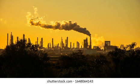 irreversible environmental damage is coming from climate change and business as usual in the oil industry looking at a doomsday smoke stack releasing pollution in corpus Christi Texas USA - Shutterstock ID 1648064143