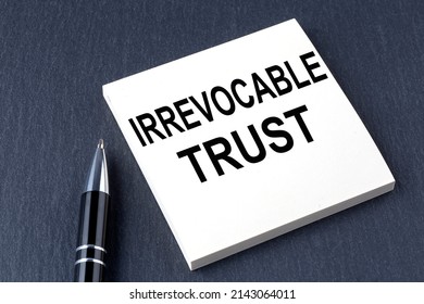 IRREVOCABLE TRUST text on sticker with pen on the black background