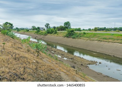 Irrigation canal in concrete wall Send water from the reservoir to the agricultural area of ​​the farmer that is dry in the rainy season of Thailand. Environmental disaster in agriculture
