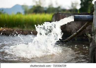 Irrigation water flow from pipe to canal for rice fields and agriculture