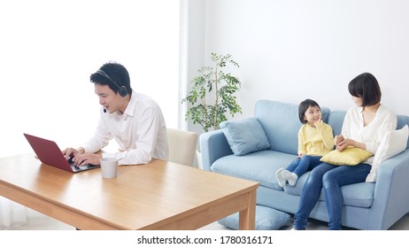 Irritated Asian Teleworking Father And His Family. Remote Working. Telework.