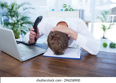 Irritated Businessman Holding A Land Line Phone In The Office