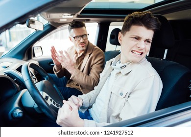 Irritated Father Gesturing To Angry Teen Son In Car