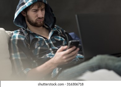 Irritated Guy Reading A Text Message From His Girlfriend