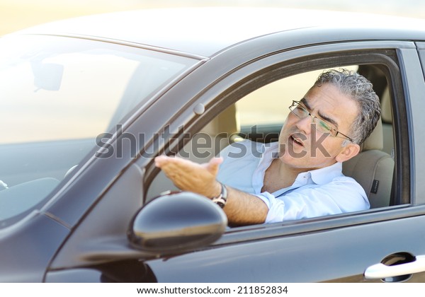  irritated male driving his car in traffic - road\
rage concept