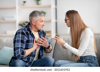 Irritated mature woman quarreling with her husband at home, being angry, experiencing family problems. Middle aged couple having conflict or disagreement. Marital crisis, breakup, divorce concept - Powered by Shutterstock