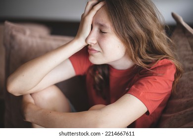 Irritated Teenage Girl Sitting On Couch, Feeling Bored, Suffering From Lack Of Communication, Being Trapped At Home During Coronavirus Lockdown, Having Teen Depression