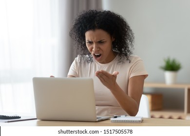 Irritated woman sitting at desk near pc swears at broken or hanging out or slow down computer having problems with task or work performing, stupid device, malware and malfunction, need repair concept - Shutterstock ID 1517505578