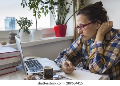 Irritated Woman Working On A Laptop At Home. Internet Trolling.