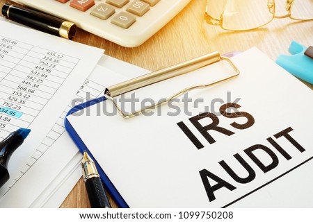 IRS audit documents with clipboard on a desk.