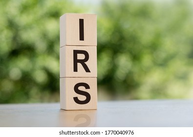 IRS Word Written On Wooden Cubes On Table With Green Background