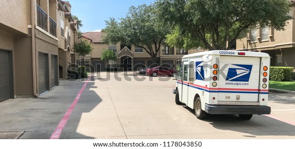 IRVING, TX, USA-SEP 7, 2018:USPS vehicle stopping\
for package delivery at apartment complex. The United States Postal\
Service is an independent agency of federal government providing\
postal service