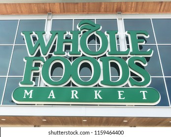 IRVING, TX, US-AUG 19, 2018:Close-up logo on exterior facade of Whole Foods Market store. An eco-minded supermarket chain featuring food without artificial preservatives, colors, flavors, sweetener