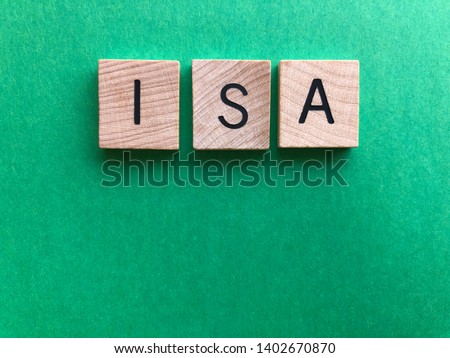 ISA / acronym for Individual Savings Account, in wooden alphabet letters on a plain green background with copy space. Creative concept, banking and finance