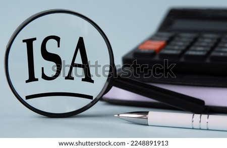 ISA (Income -Share Agreement) - acronym on magnifying glass on a light background with calculator, notepad and pen. Business and finance concept