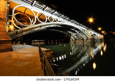 Isabel II bridge over Guadalquivir river at sunset with river reflections in Sevilla, Andalusia, Spain