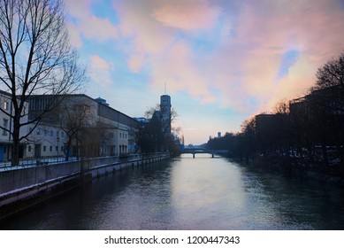 Isar River Munich With View To Well Known Deutsches Museum And Bridge At Sunset In Winter