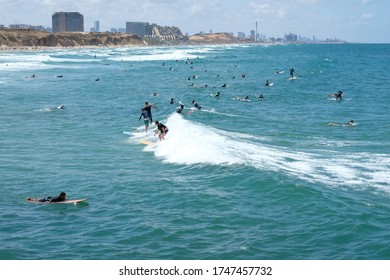 ISAREL - Herzliya, 29 May 2020: a large group of surfers rides surfs in the sea after quarantine removal