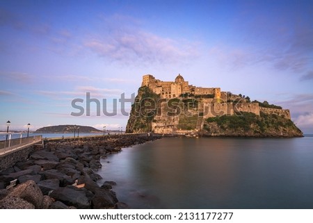 Ischia, Italy with Aragonese Castle in the Mediterranean at dusk.