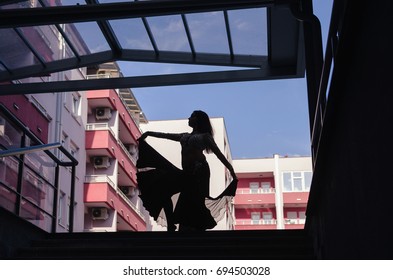 Islam Girl Dancing. Silhouette Of Woman Dancing Surrounded By Buildings. Teacher Shows The Steps And Points To Pupils In The Belly Dance Class. Oriental Dance.