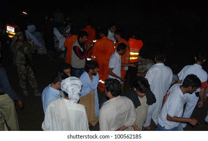 ISLAMABAD, PAKISTAN - APR 20: Rescue Working Work In Dark And Rain At The Site Of The Plane Crash Near Pakistan's Capital City Of Islamabad That Killed All 127 Passengers April 20, 2012 In Islamabad.