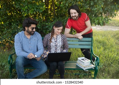 Islamabad, Pakistan. October 8th, 2019. People Sitting In The Park And Looking At Laptop With Books On Bench.