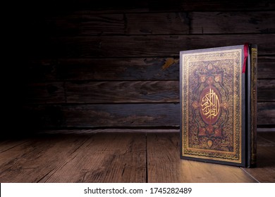 Islamic concept - The Holy Al Quran with written Arabic calligraphy meaning of Al Quran, Arabic word translation : The Holy Al Quran (holy book of Muslim), on black background, with copy space.