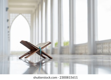 Islamic concept - The Holy Al Quran with written Arabic calligraphy meaning of Al Quran and rosary beads or tasbih, Arabic word translation: The Holy Al Quran (holy book of Muslim)  - Shutterstock ID 2300815611