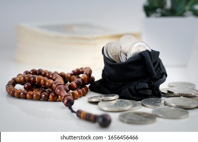 Islamic Finance With Rosary And Coin On Table.  