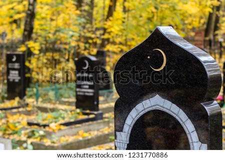Islamic symbol crescent moon with a star on a gravestone. Muslim cemetery autumn background 