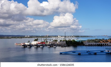 island harbor partly in shadow with several small boats and coastal homes, a view of the sky, island, and sea - Powered by Shutterstock