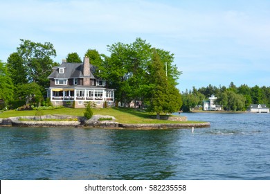 Island with house, cottage or villa in Thousand Islands Region in sunny summer day in Kingston, Ontario, Canada. 1000 Islands near Gananoque, ON. Famous Canadian tourist vacation routs.