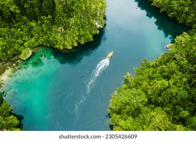 Island, ocean and drone view of a boat in nature with trees for sailing on vacation or weekend trip. Travel, adventure and aerial view of speedboat on sea of tropical resort water for summer holiday. - Powered by Shutterstock