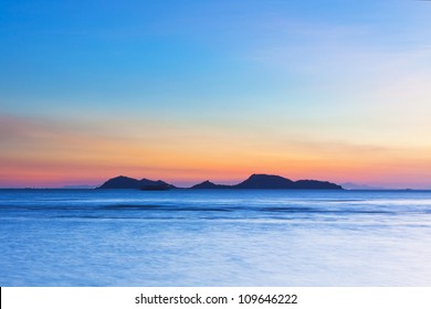 Island At Sunset Over The Ocean