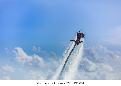 Island Sunset. Professional Fly Board Rider Doing Back Flip With Tropical Resort Island Background. Sunset Sport And Summer Activity Background, Fun Water Sport