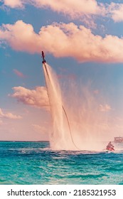 Island Sunset. Professional Fly Board Rider Doing Back Flip With Tropical Resort Island Background. Sunset Sport And Summer Activity Background, Fun Water Sport